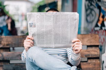 Photographie d'un homme lisant un journal